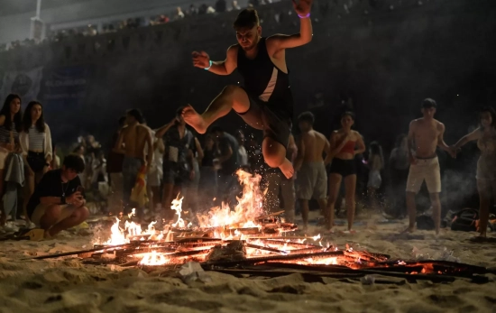 Una persona salta una hoguera durante la Noche de San Juan, en la playa de Riazor M. Dylan EP Una persona salta una hoguera durante la Noche de San Juan, en la playa de Riazor M. Dylan EP