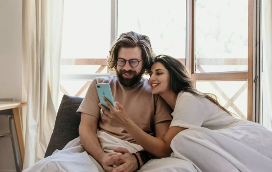 Una persona enseña algo en su móvil a otra / PEXELS