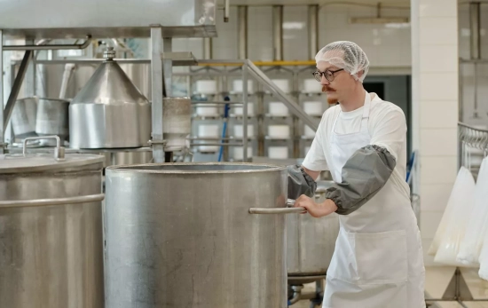 Un trabajador de una fábrica de lácteos como la que produce el queso cottage de Mercadona/ CANVA