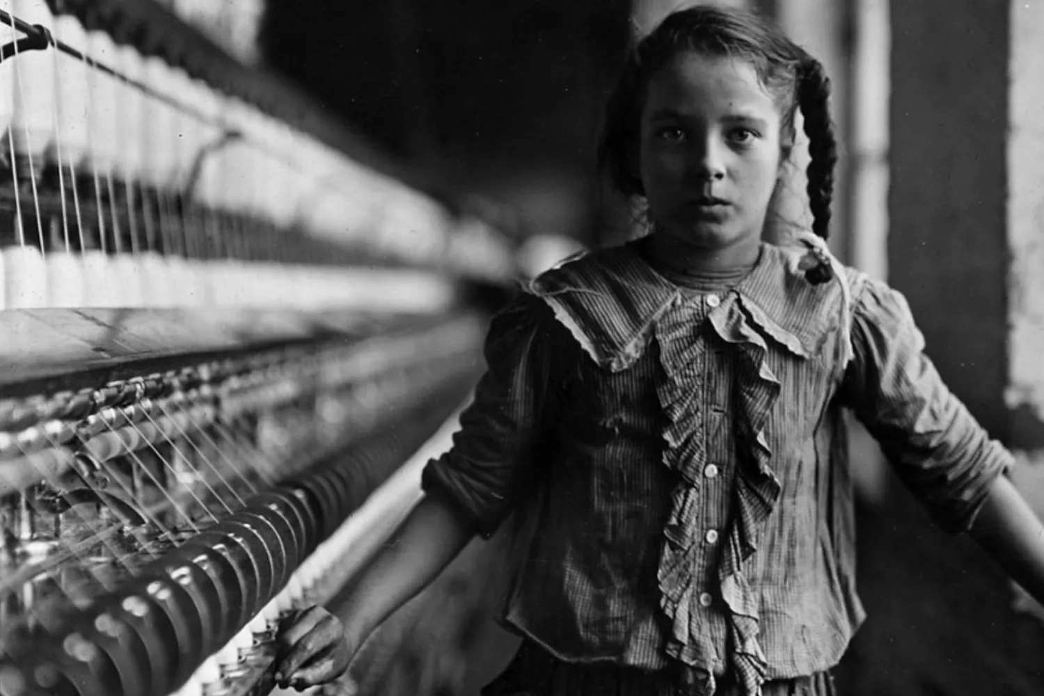 Uma trabalhadora adolescente numa fábrica de algodão na Carolina do Norte (Estados Unidos) em 1908 / LEWIS HINE - WIKIPÉDIA