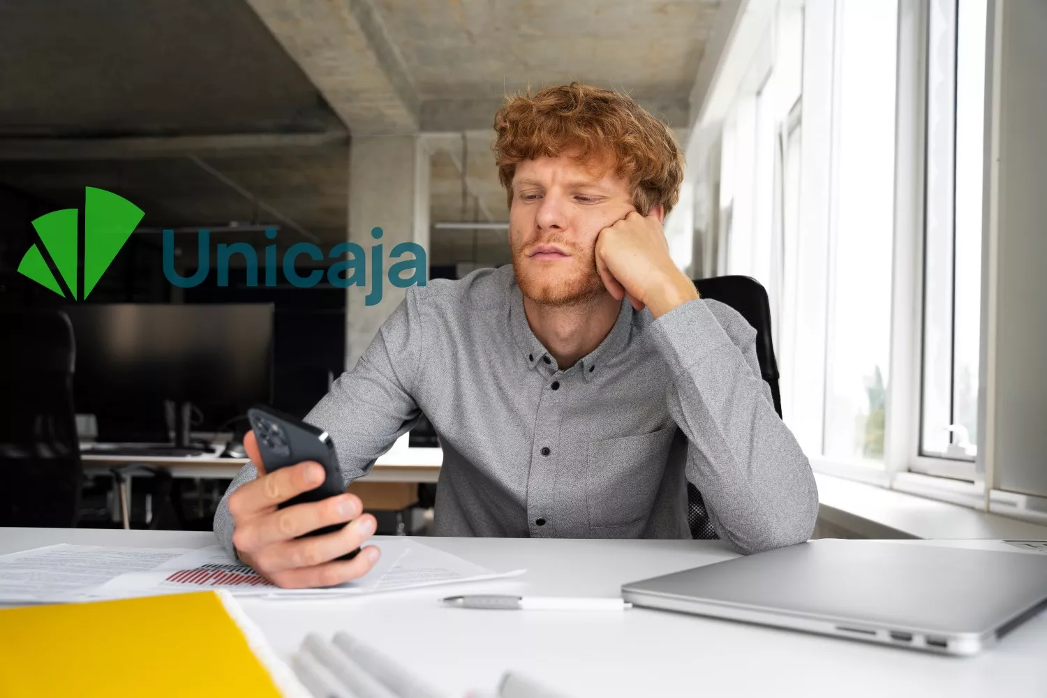 Un joven cliente de Unicaja mira su móvil (1)