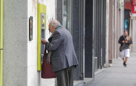 Una persona mayor saca dinero de un cajero / EUROPA PRESS - JESUS HELLÍN