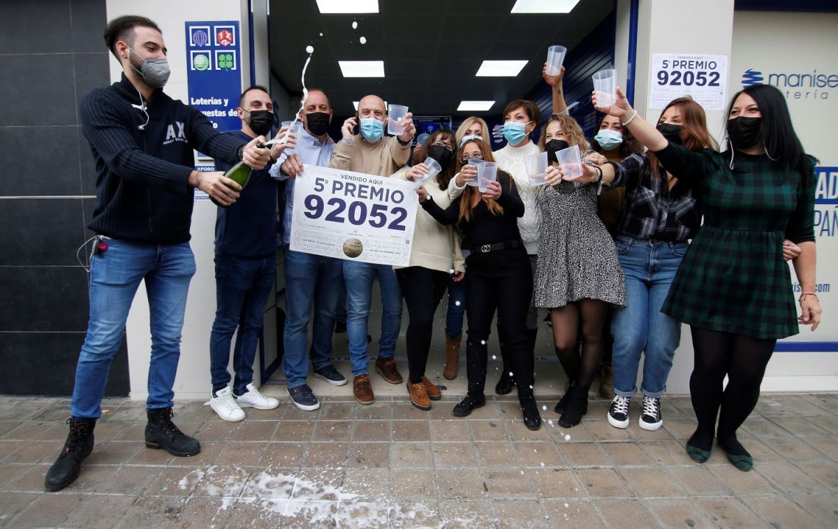 Varias personas celebran un quinto premio frente a una administración de lotería / EFE - Miguel Ángel Polo