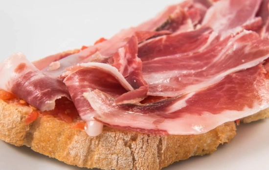 Pan con tomate y jamón/ CANVA Pan con tomate y jamón/ CANVA