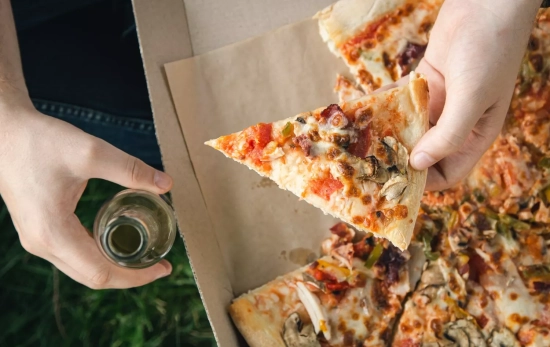 Una persona con una pizza / FREEPIK - pvproductions