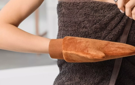 Una persona usando un guante para aplicarse bien el autobronceador/ CANVA Una persona usando un guante para aplicarse bien el autobronceador/ CANVA
