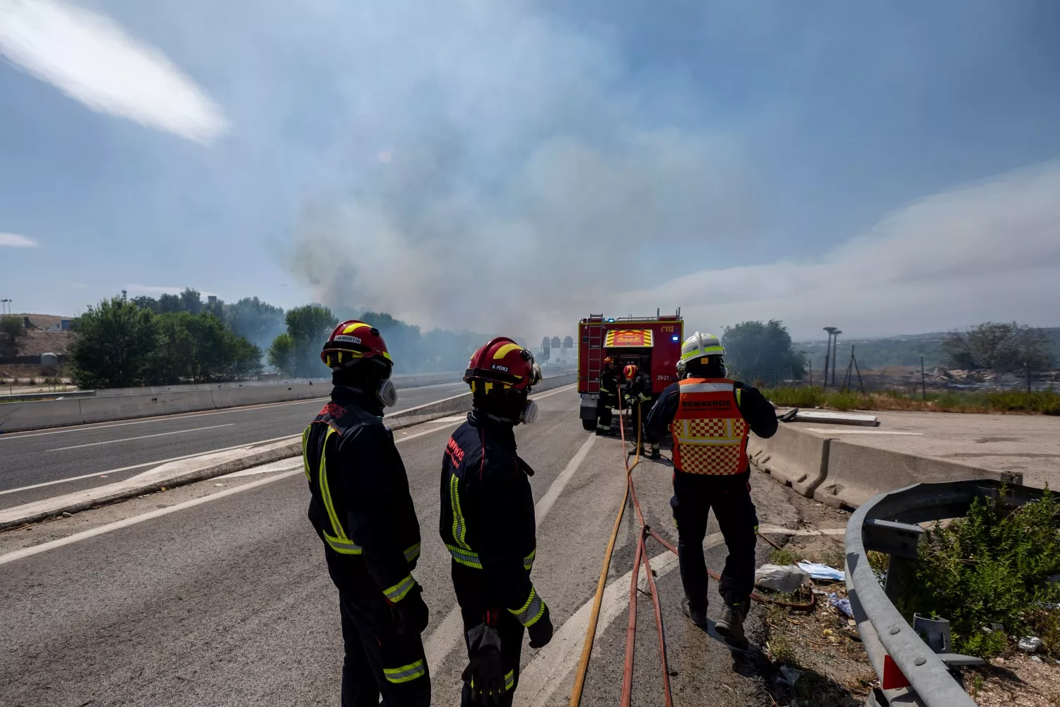 Bomberos trabajan en las labores de extinción de un incendio forestal, en la carretera M 206   Alber