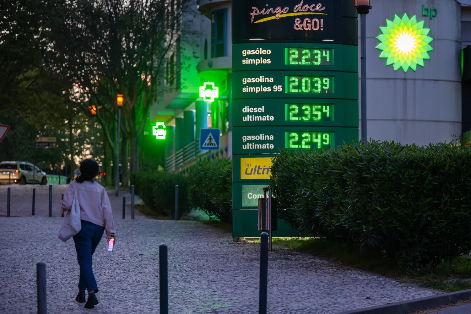 Una persona camina cerca de un panel con el precio del combustible en una gasolinera de Lisboa, Portugal / Jorge Castellanos - EP