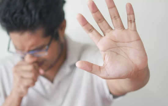 Una persona con un ataque de tos/ CANVA
