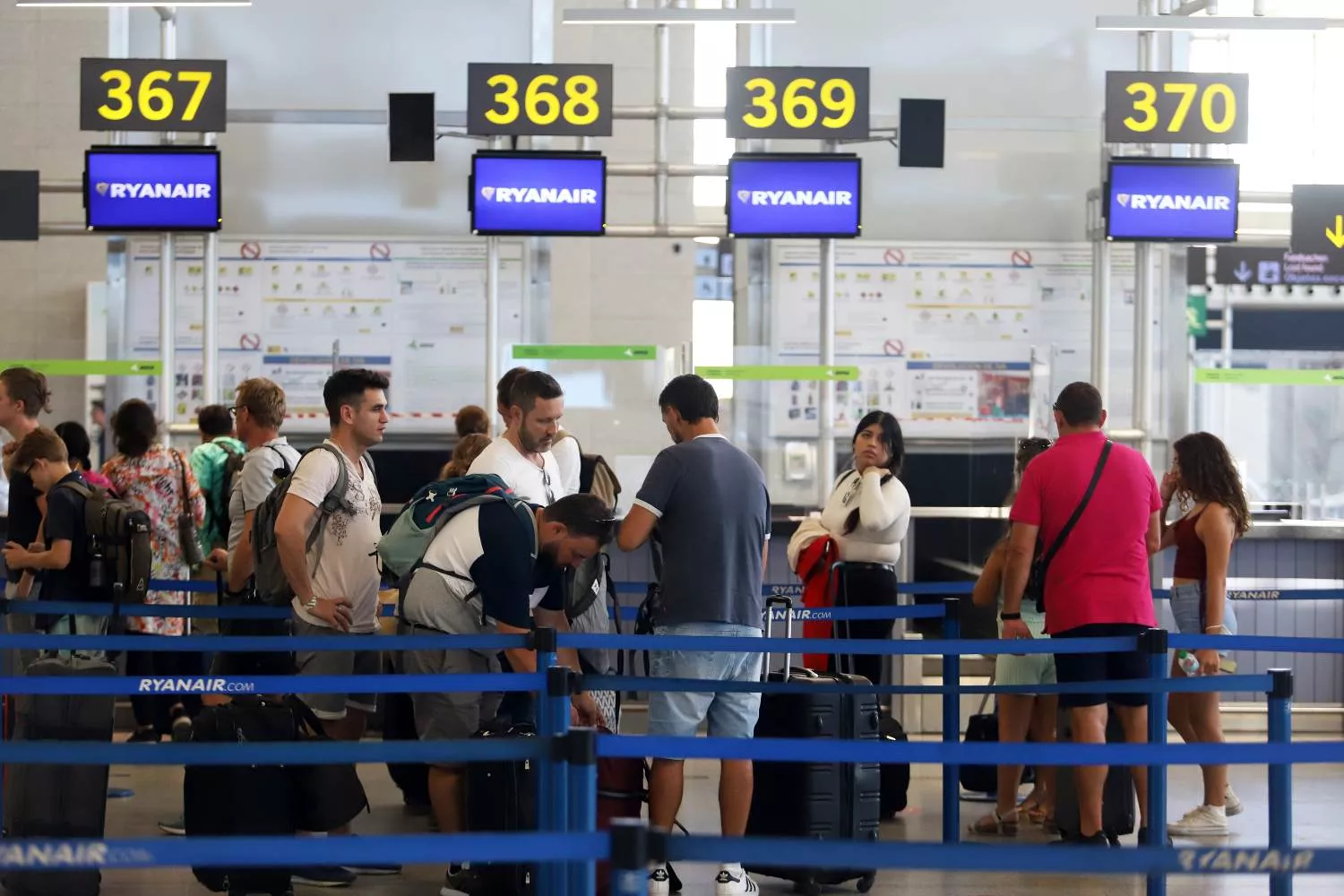 turistas hacen colas en los puestos de embarque de Ryanair