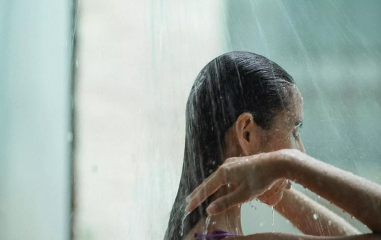Una chica lavándose el pelo tras la playa/ CANVA Una chica lavándose el pelo tras la playa/ CANVA