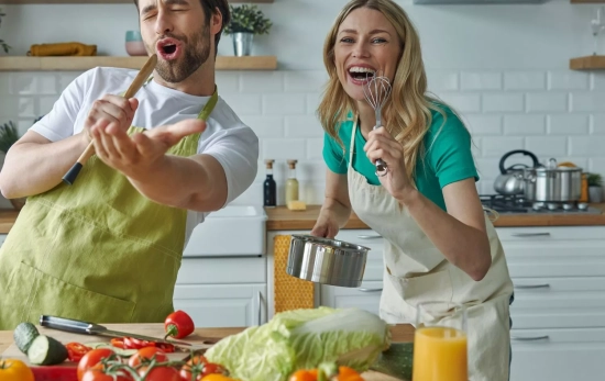 Una pareja canta mientras cocina/ CANVA Una pareja canta mientras cocina/ CANVA