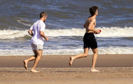 Dos personas corriendo en la playa/ CANVA Dos personas corriendo en la playa/ CANVA