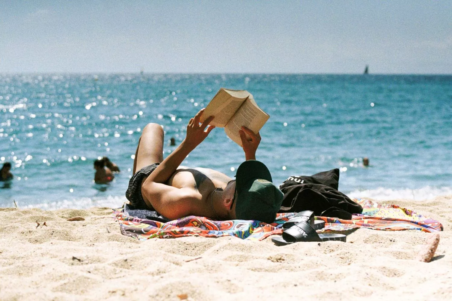 Una persona lee en la playa   UNSPLASH