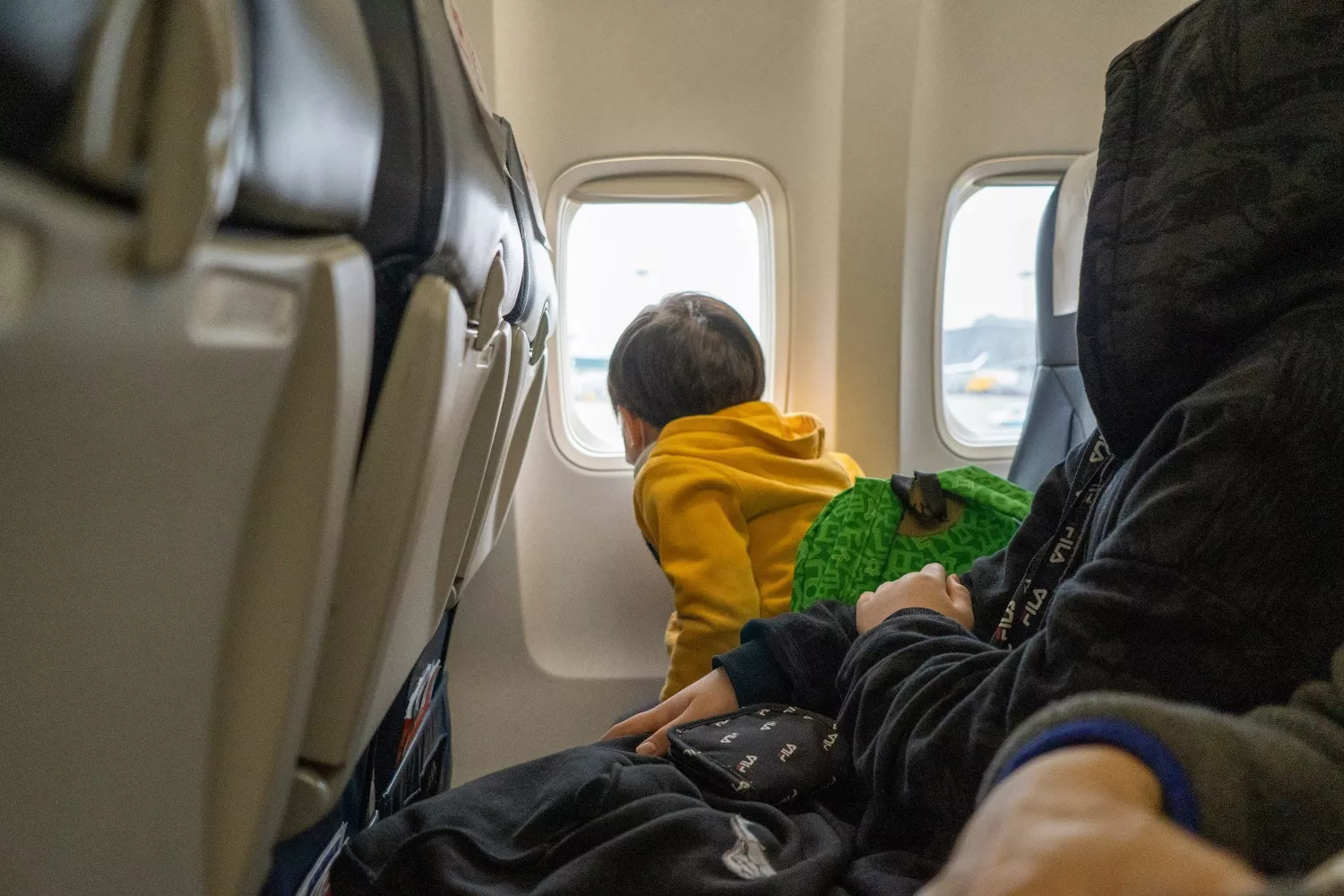 Un niño mira por la ventanilla de un avión   UNSPLASH