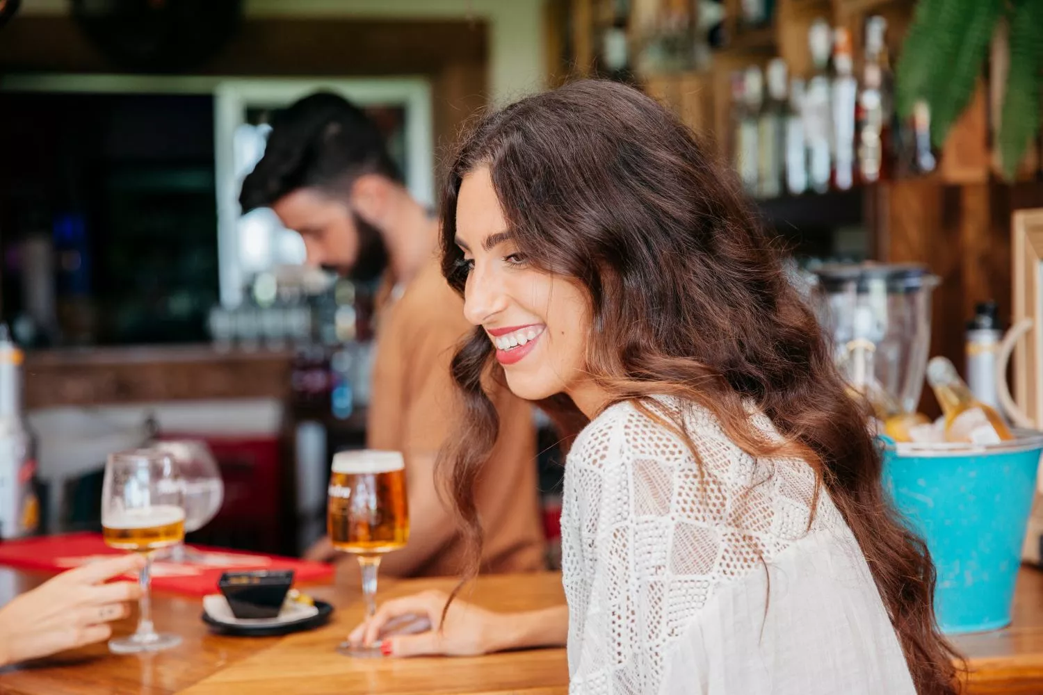 Una persona con una cerveza en un bar / MAGNIFIC