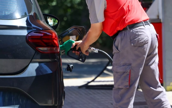 Una persona reposta gasolina en un coche Una persona reposta gasolina en un coche