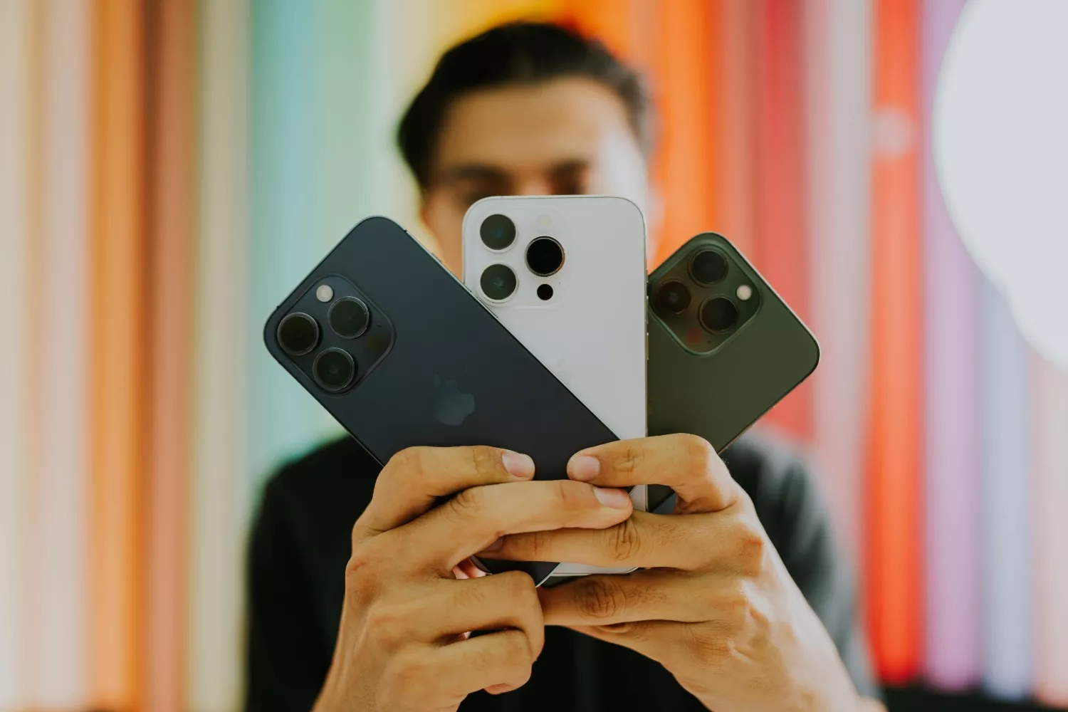 Una persona sostiene varios modelos de iPhone / PEXELS