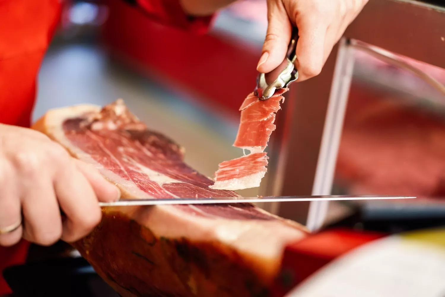 Una persona corta jamón serrano