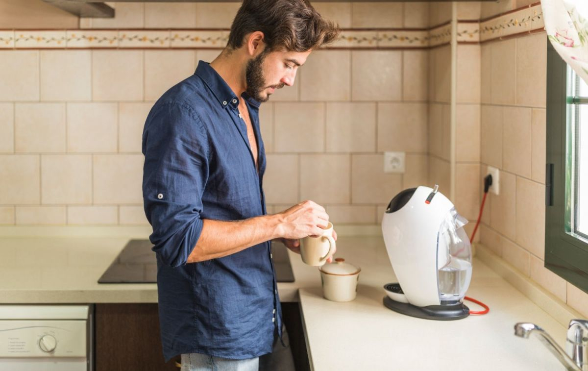 Un hombre que se hace un café en una cafetera con cápsulas / FREEPIK