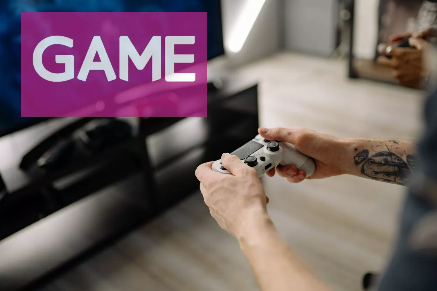 Una persona con el mando de una consola y el logo de Game de fondo / GAME