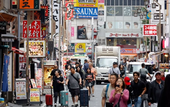 Turistas caminan con maletas por el distrito de ocio de Shinjuku, en Tokio, Japón / FRANCK ROBICHON - EFE Turistas caminan con maletas por el distrito de ocio de Shinjuku, en Tokio, Japón / FRANCK ROBICHON - EFE