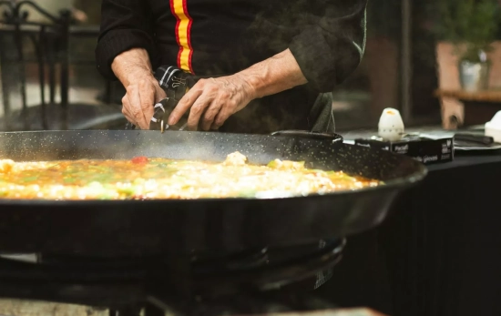 Un cocinero prepara una paella