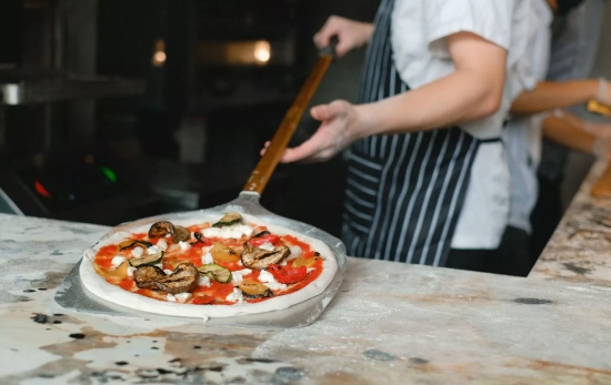 Un pizzero prepara una pizza / PEXELS Un pizzero prepara una pizza / PEXELS