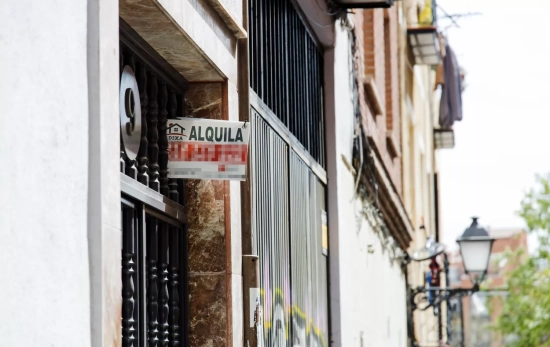 Un cartel de 'Alquila' de una inmobiliaria, en un portal del distrito de Embajadores Un cartel de 'Alquila' de una inmobiliaria, en un portal del distrito de Embajadores