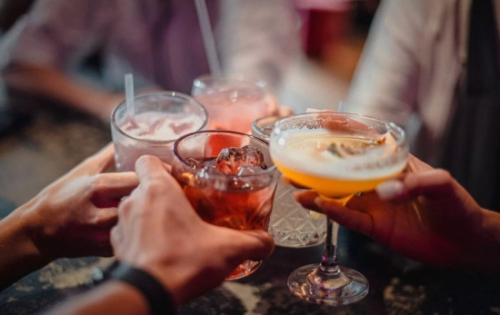 Varias personas brindan con sus bebidas / UNSPLASH