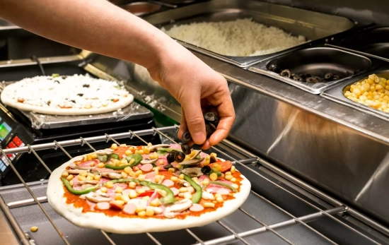 Una persona prepara una pizza