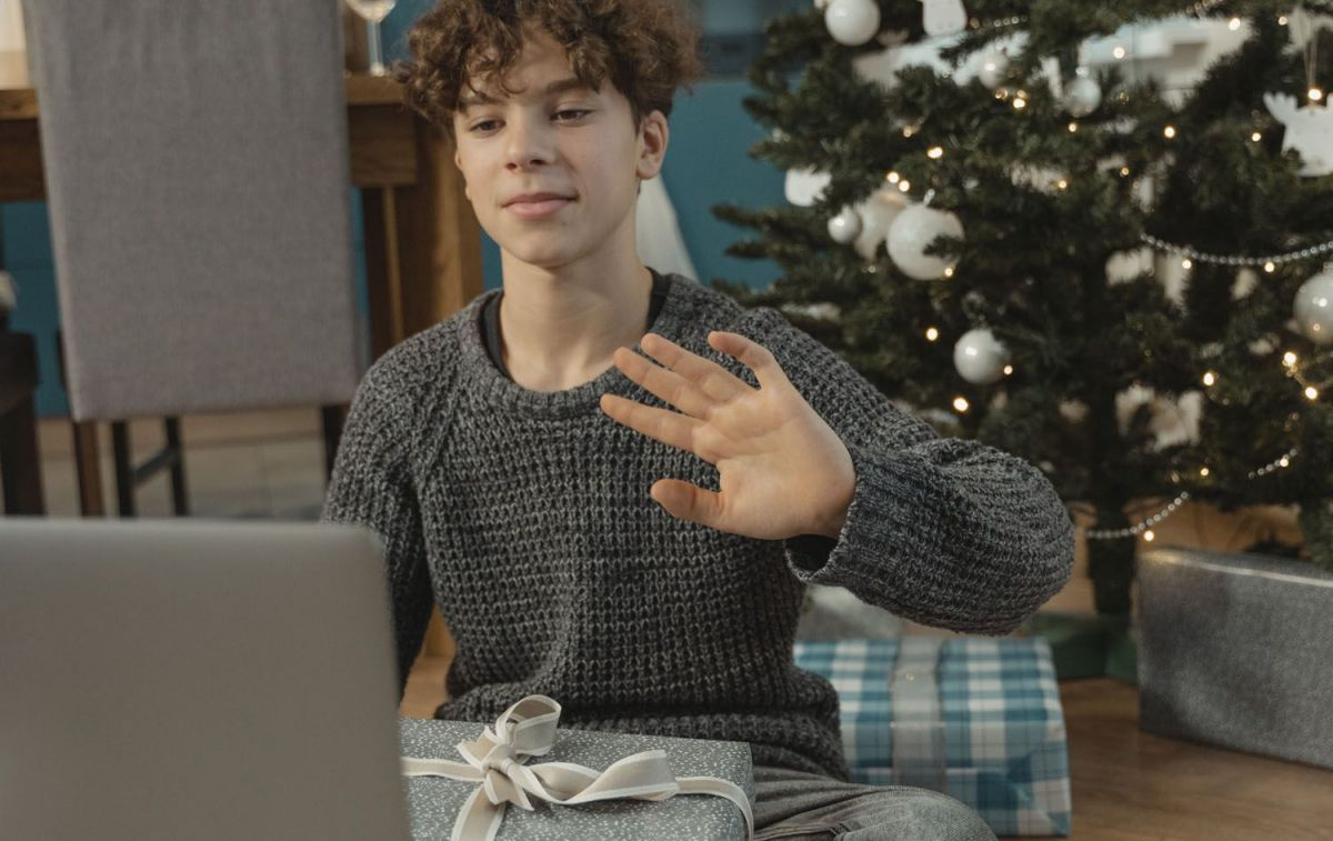 Un chico abre un regalo de los Reyes Magos y comprueba la garantía del mismo en el ordenador / PEXELS