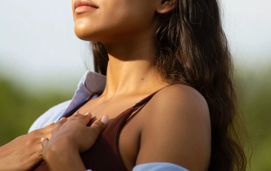 Una mujer oliendo su propio perfume sensorial/ CANVA