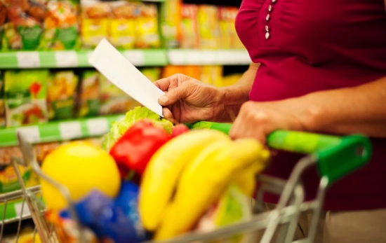 Una persona con un carrito y una lista de la compra / MAGNIFIC - gpointstudio