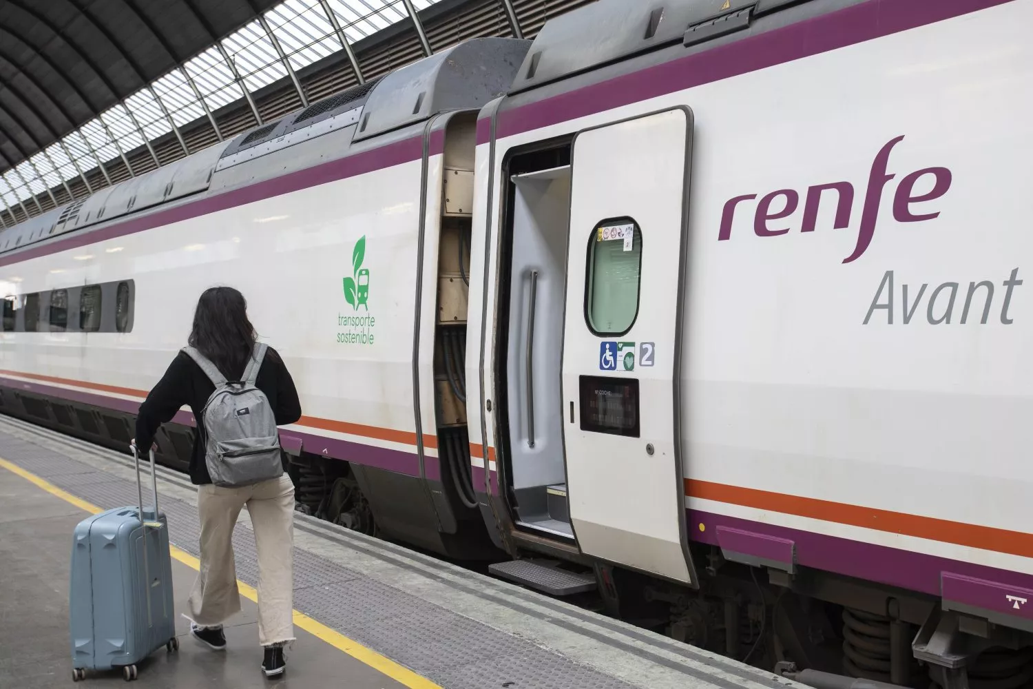 Una persona junto a un tren de Avant / RENFE