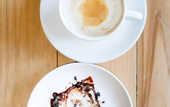 Un café y un plato de postre acabado en la sobremesa/ CANVA Un café y un plato de postre acabado en la sobremesa/ CANVA