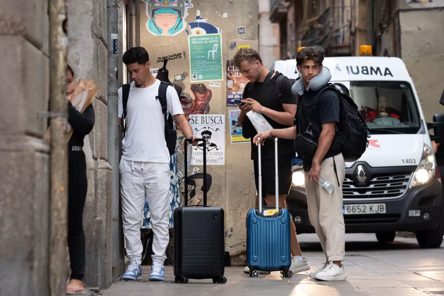 Varias personas con maletas en el centro de Barcelona