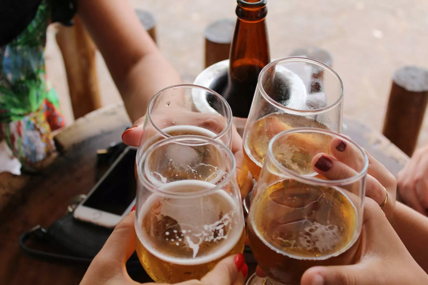 Varias personas brindan con cervezas / UNSPLASH