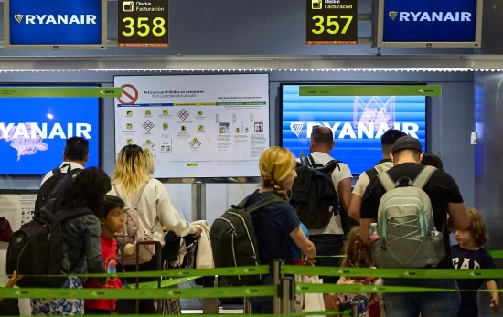 Un grupo de personas en un puesto de facturación de Ryanair / EUROPA PRESS -JESÚS HELLÍN