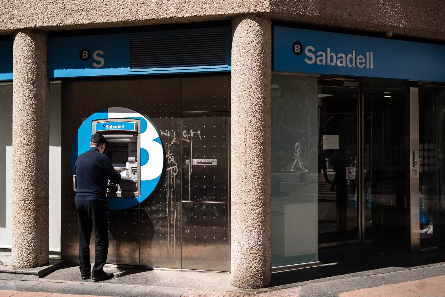 Un hombre en el cajero de la entidad bancaria Sabadell / EUROPA PRESS - DIEGO RADAMÉS