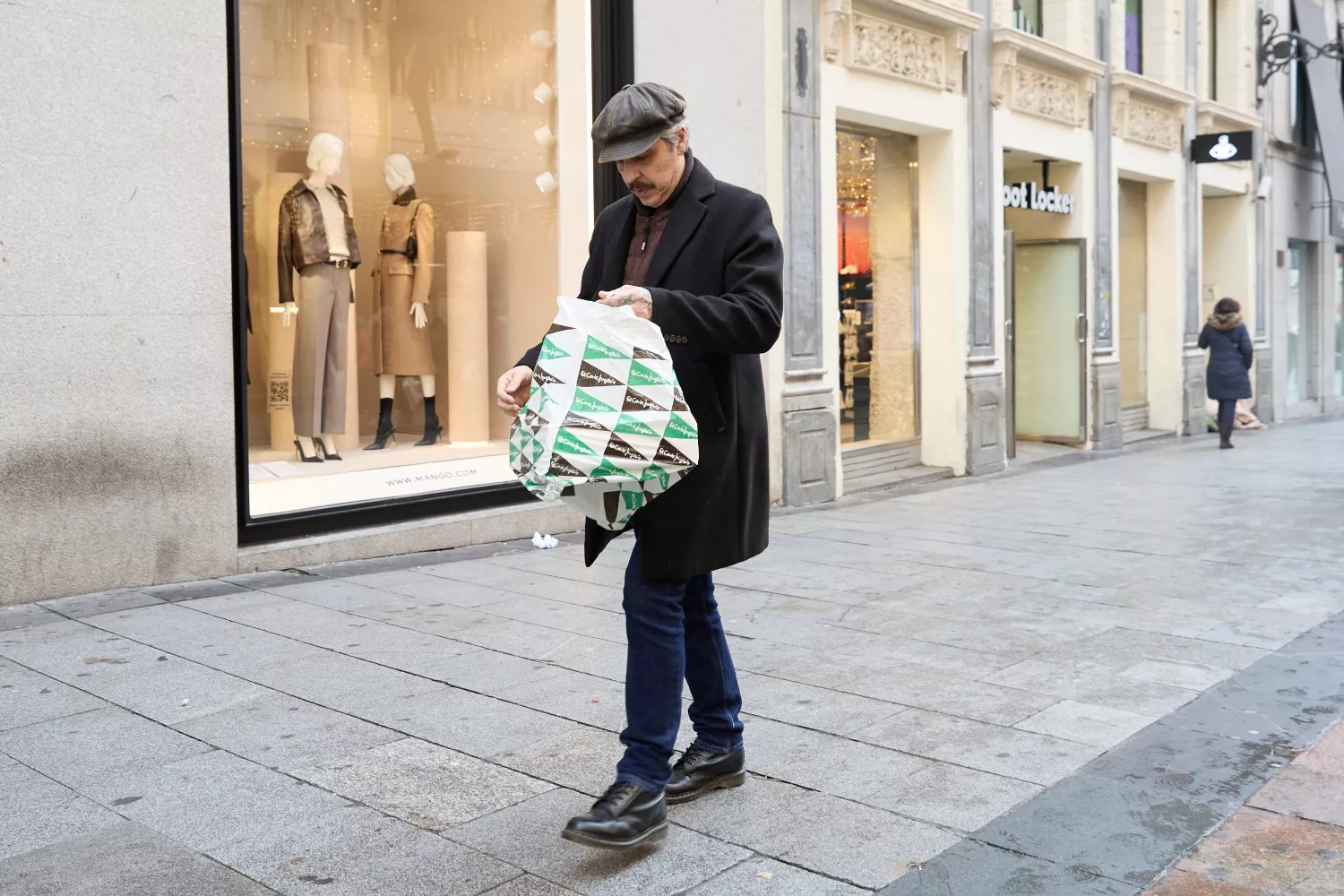 Un hombre con una bolsa tras comprar en las rebajas / Jesús Hellín - EP