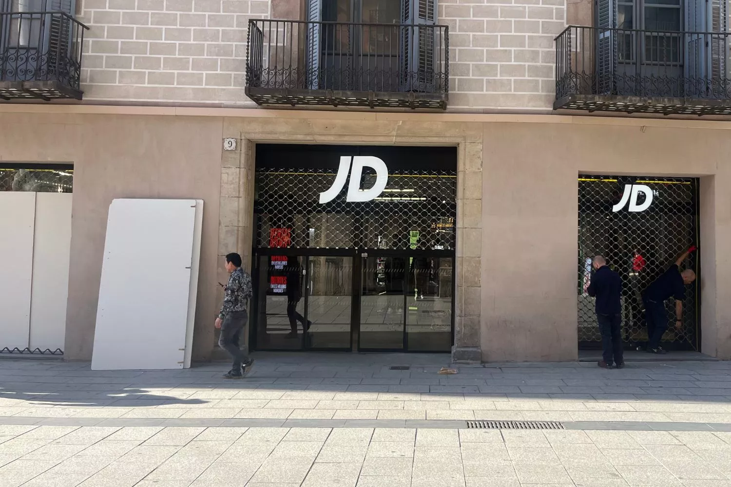 Operarios miden el escaparate de la tienda JD Sports de portal de l'Àngel de Barcelona tras el saqueo / TEO CAMINO