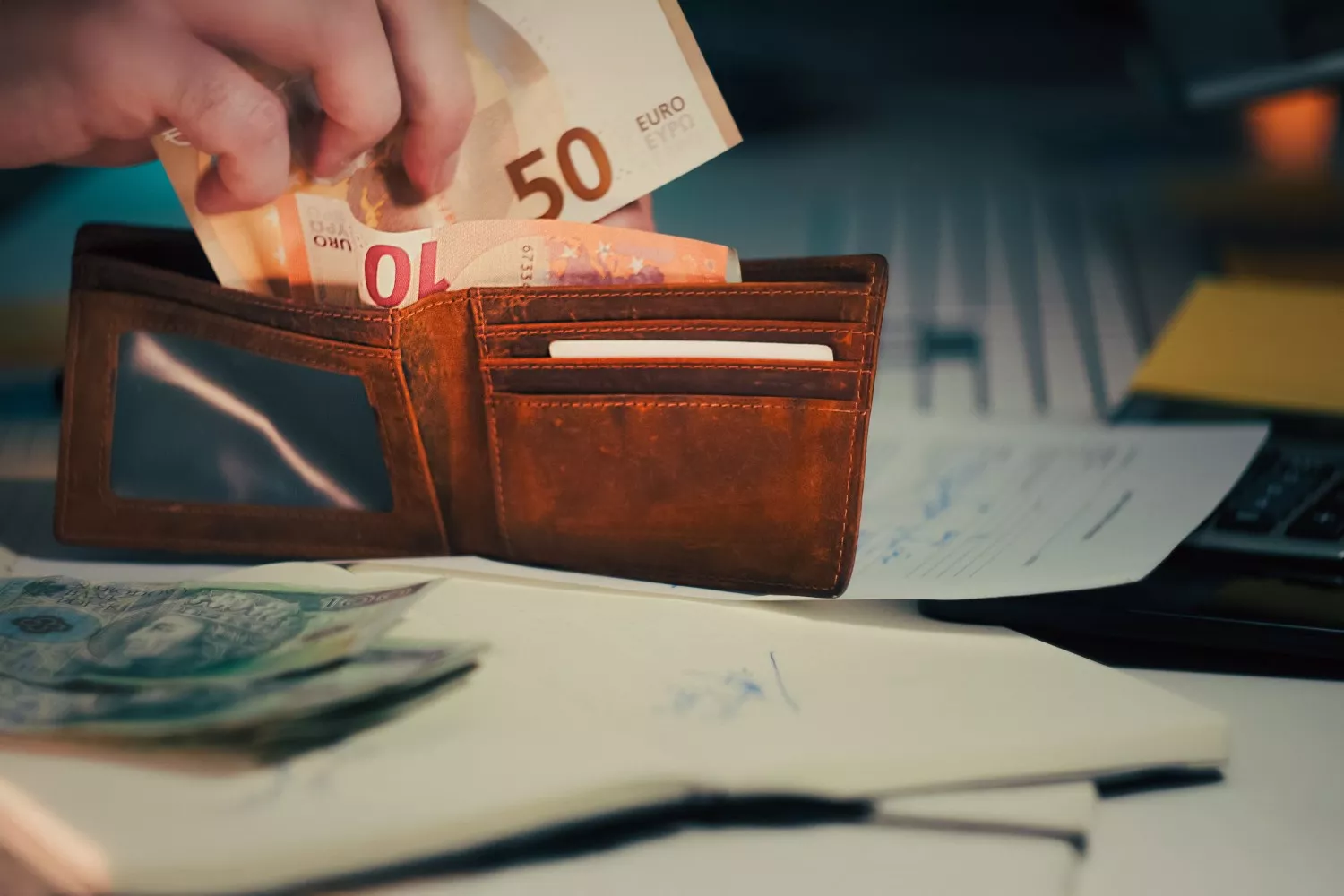 Una persona guarda dinero en la cartera   PEXELS