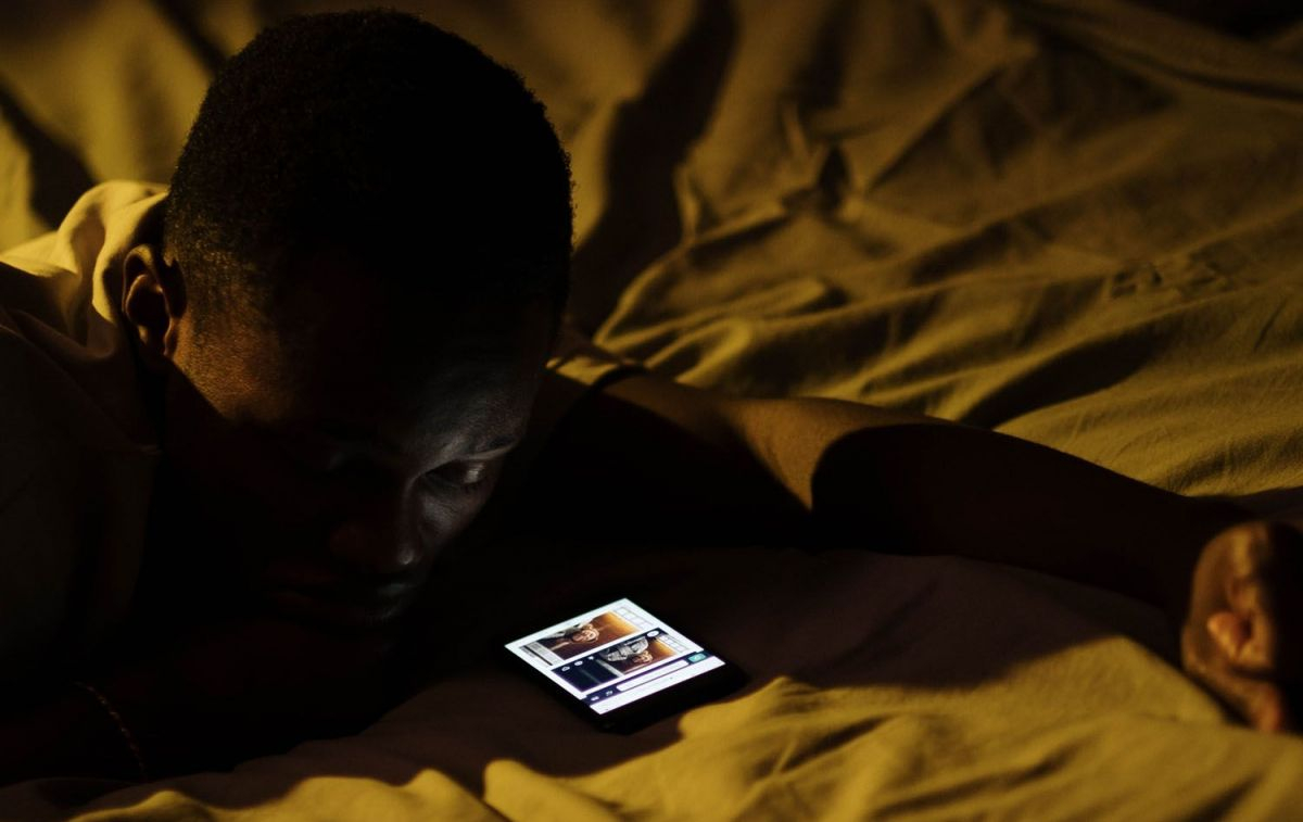 Un joven con su móvil en la cama / PEXELS
