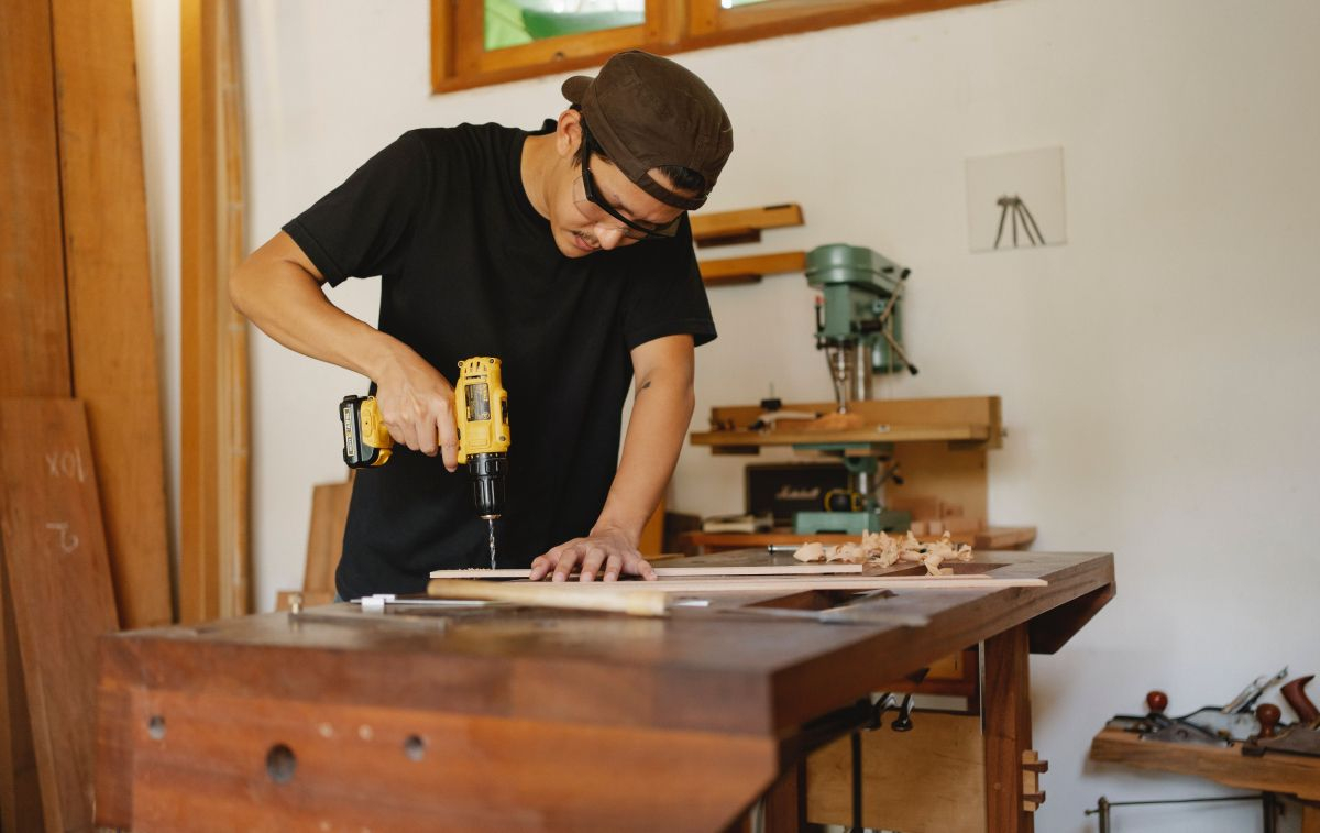 Un hombre utiliza su lijadora para crear un mueble en una sesión de bricolaje / PEXELS