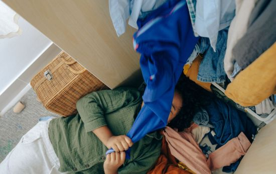 Una persona trata de sacar una prenda de un armario sin orden / UNSPLASH Una persona trata de sacar una prenda de un armario sin orden / UNSPLASH