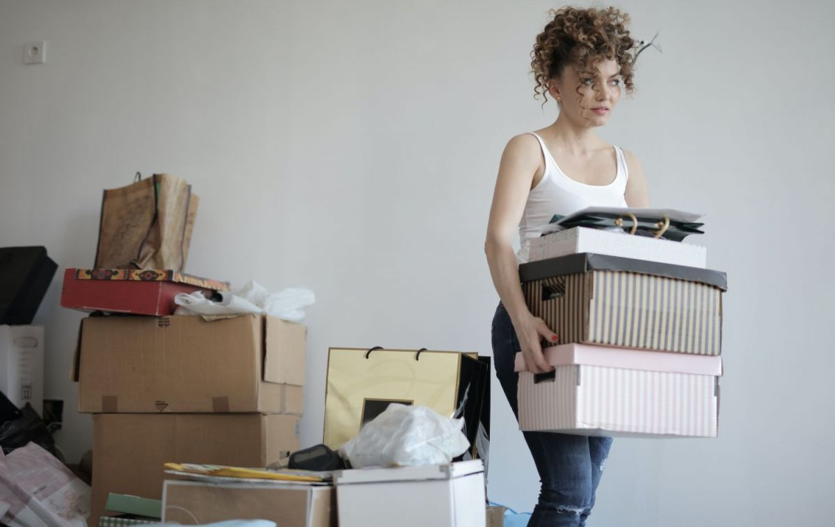 Una mujer trata de poner orden almacenando objetos en cajas / PEXELS