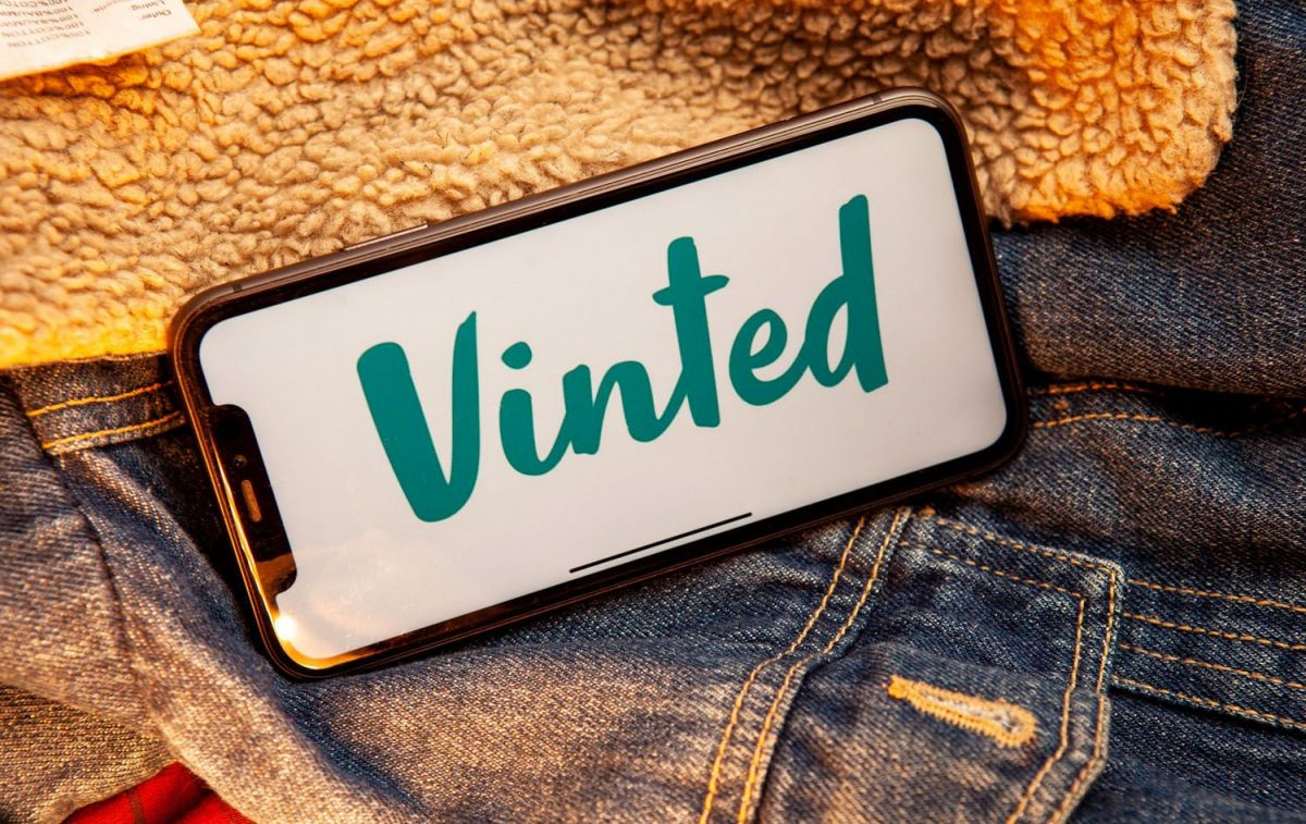 Un móvil con la aplicación de Vinted sobre varias piezas de ropa / VINTED