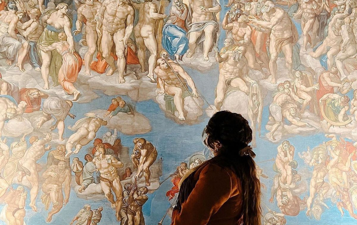 Una mujer contempla uno de los frescos de La Capilla Sixtina / PINTEREST