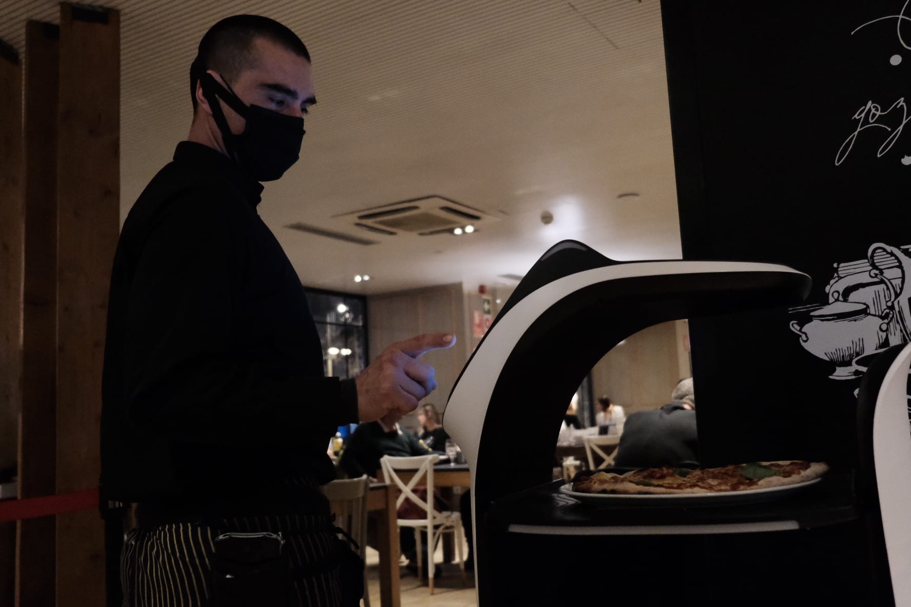 El Bellabot con un camarero en el restaurante de La Poma / CG
